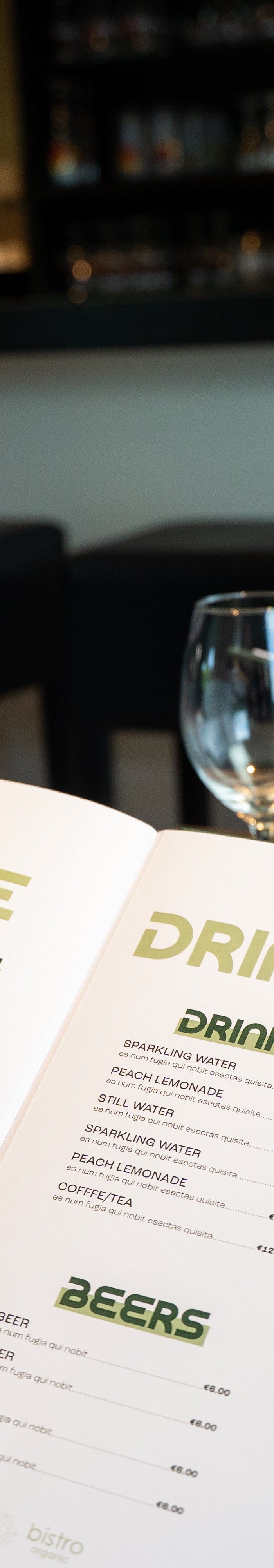 Two guests sitting in a restaurant looking at a personalised drinks menu cover