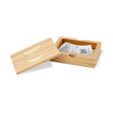 A bamboo bill box with a lid, partially open, displaying a white card with the brand 'Bistro' printed on it, and containing some colorful buttons or candies.