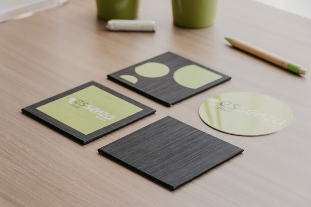 Set of coasters with a brand logo on a wooden surface
